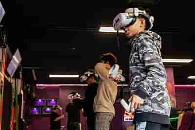 A group of school children playing VR games together