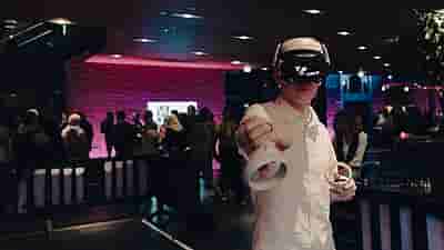 A person wearing a VR headset with VRcafe Haarlem logo at an event location