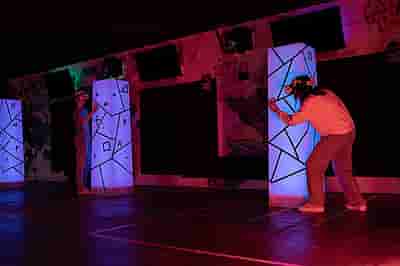 Two people shooting each other in a laser tag game hiding behind towers in real life