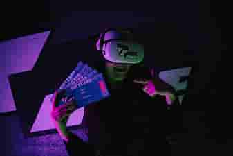 Woman in Meta Quest 2 headset with VRcafe Haarlem logo sticker on it holding 3 giftcards