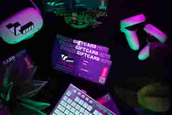 VRcafe giftcard laying on the table near a white/silver keyboard and some plants