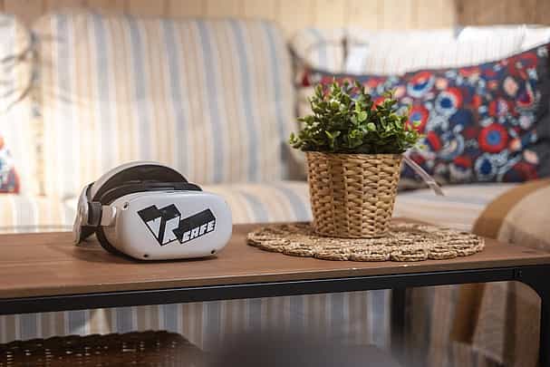 Meta Quest 2 headset rent from VRcafe Haarlem laying in a living room on an oak table near a plant