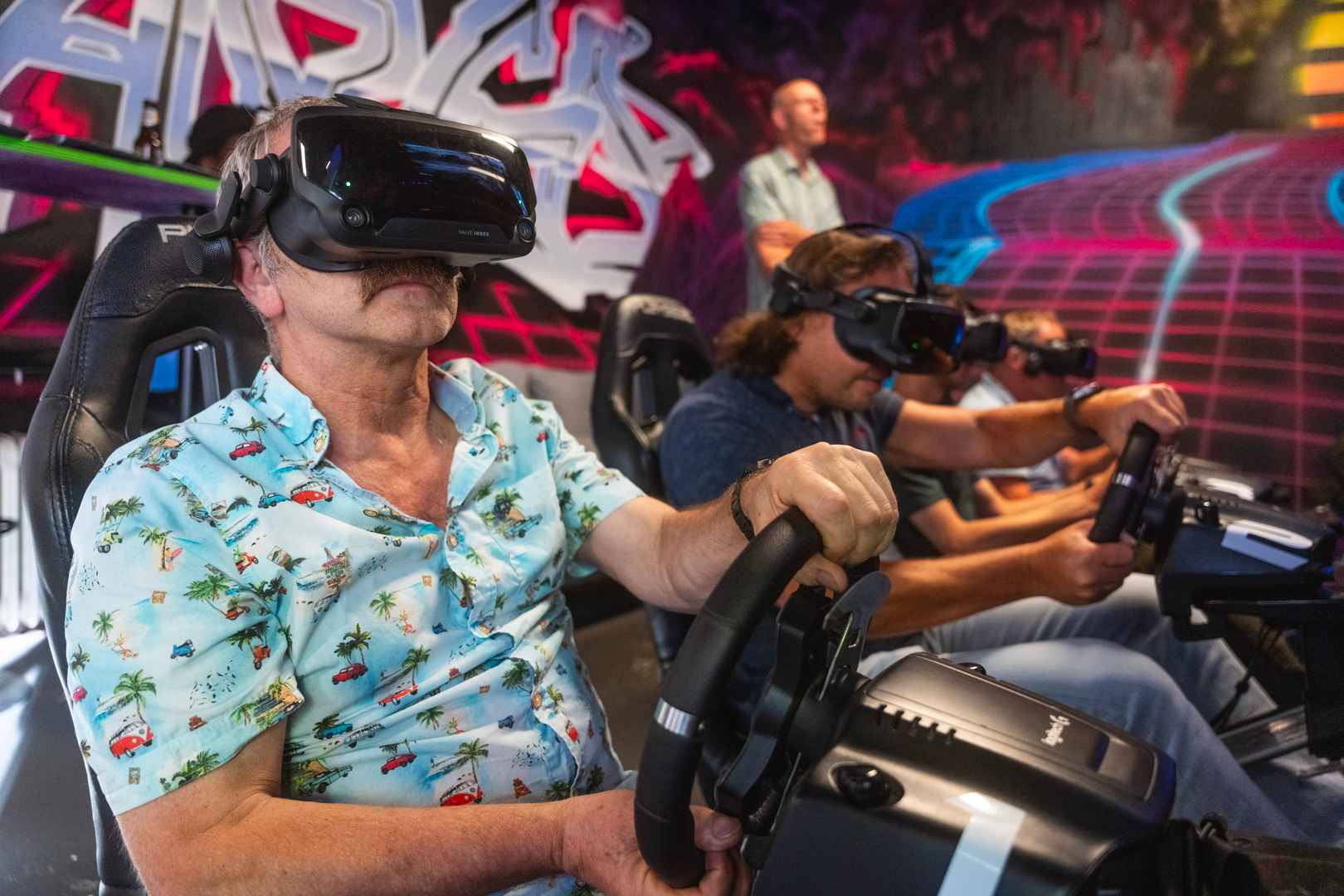 4 men racing on a F1 track in Valve Index headsets during a company outing