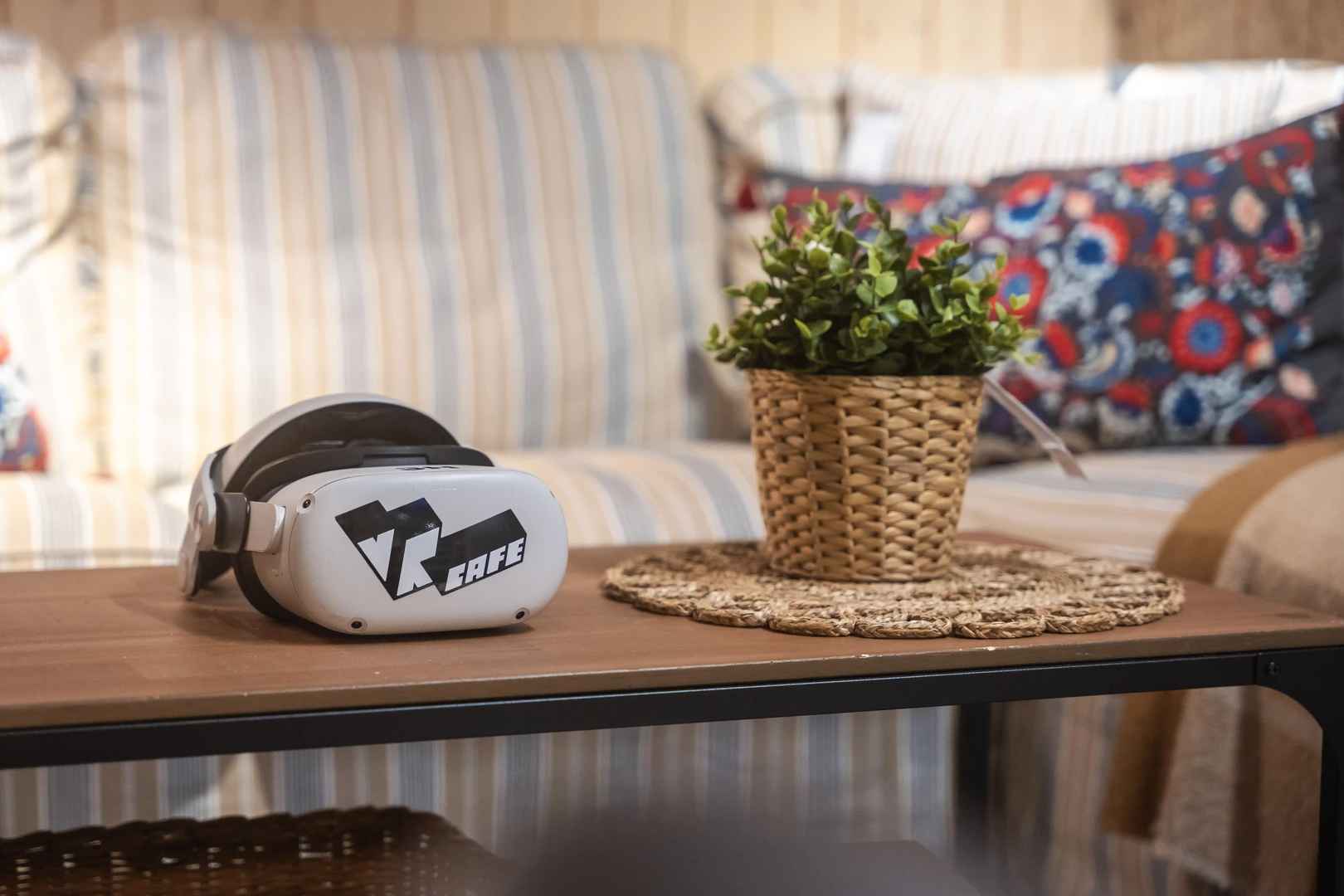Meta Quest 2 headset rent from VRcafe Haarlem laying in a living room on an oak table near a plant
