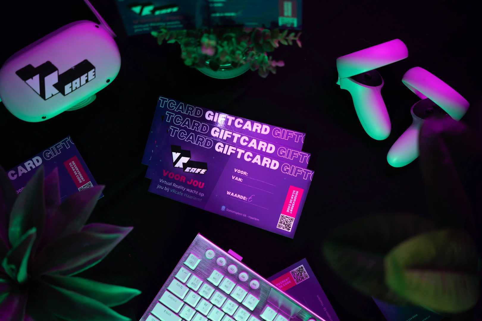 VRcafe giftcard laying on the table near a white/silver keyboard and some plants