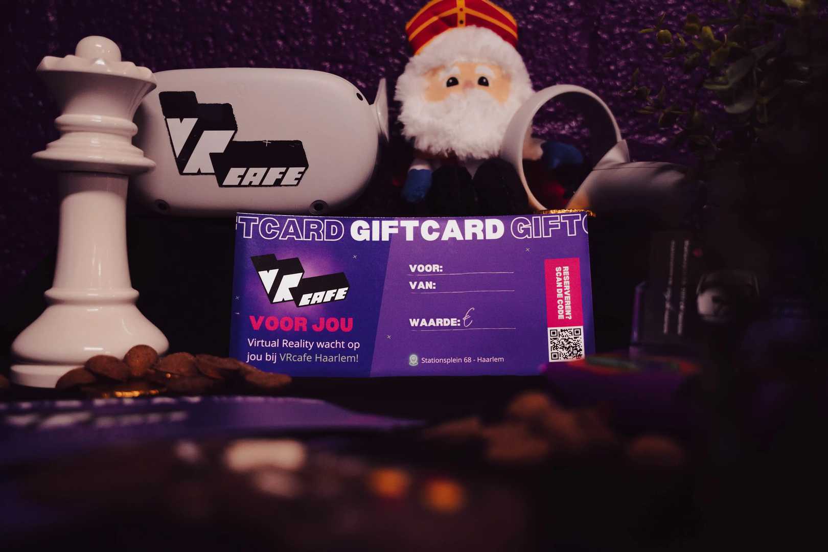 VRcafe Haarlem giftcard standing against a purple wall with Sinterklaas plushie and controllers nearby